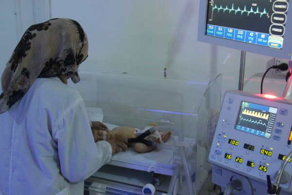 A nurse in a hospital in rural Idlib examines an infant. Photo: IWPR