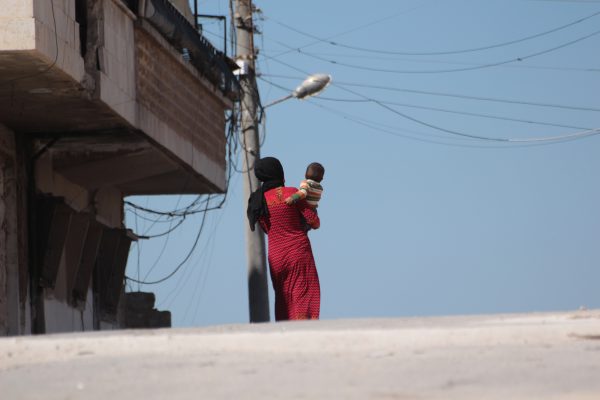 A woman from Idlib's countryside carrying her son. Photo by: IWPR