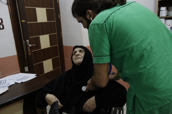 An elderly woman is examined at the internal medicine clinic of the al-Quds hospital in Aleppo. Photo: Mujahid Abu al-Jud.