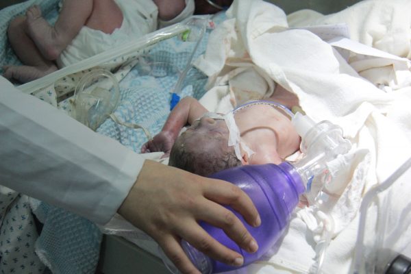 ممرضة مناوبة في قسم الحضانات في احدى مشافي ريف ادلب تتفقد أحد الرضع- تصوير معهد صحافة الحرب والسلام