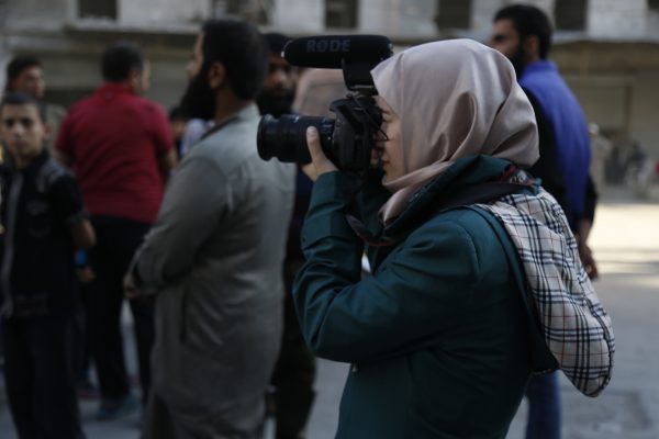 A journalist takes pictures of an Aleppo demonstration calling on the Free Syrian Army to break the siege of the city. Photo: Mujahid Abu al-Joud