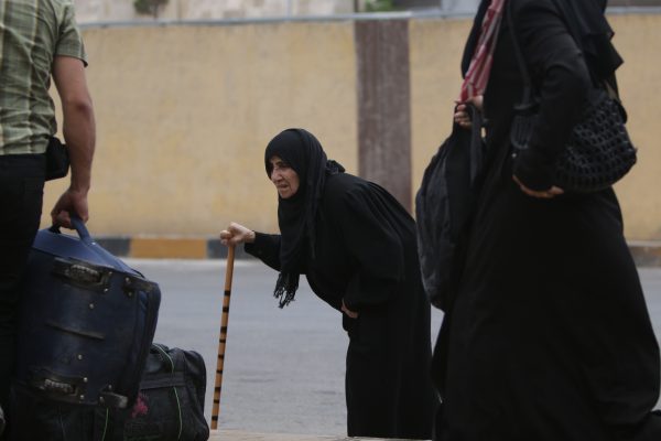 سيدة مسنة عند المعبر ورحلة العودة إلى سوريا تصوير أحمد عبيد