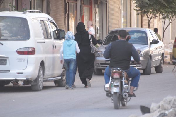 A woman with her children goes to visit relatives. Photo: IWPR