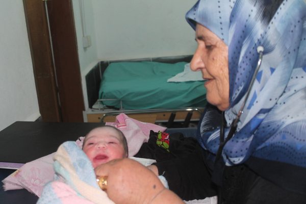القابلة القانونية أم محمد تتفقد المولود الجديد تصوير سيسيليا