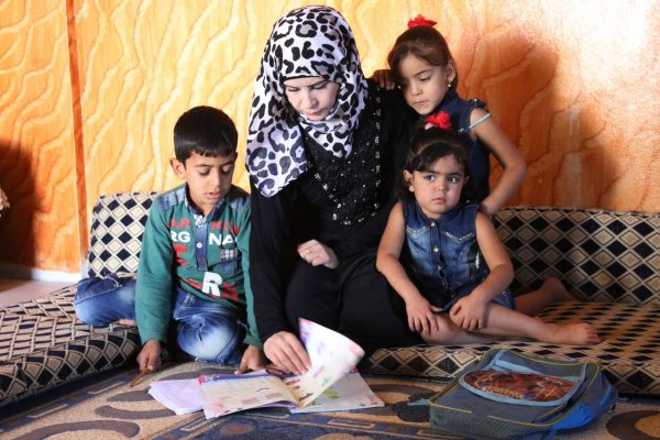 انسة سورية تعطي درساً لاطفال نازحين داخل خيمة أقيمت كمدرسة مؤقتة لتعليم الأطفال في بلدة الغارية الشرقية بريف درعا