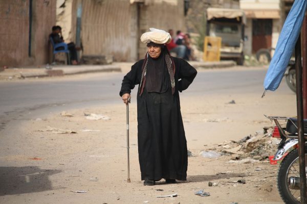 امرأة سورية مسنة تحمل كيساً من الخبز فوق رأسها في أد أحياء مدينة درعا في جنوب سوريا