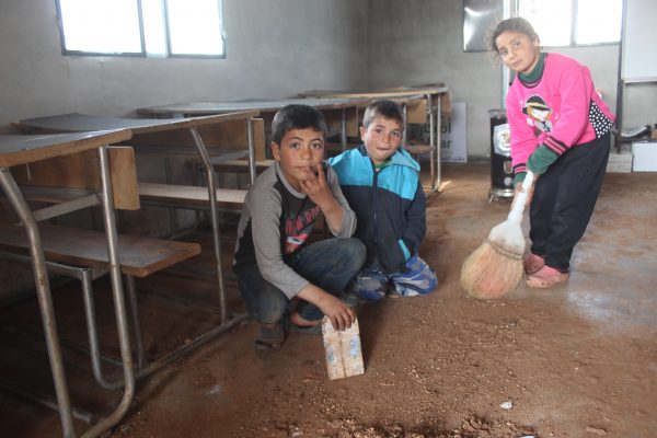 8. ثلاثة أطفال يحاولن تنظف صفهم، المدرسي، في احدة المخيمات الواقعة في ريف حماة