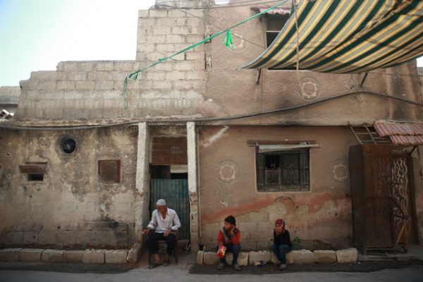 رجل كبير في السن يجلس في أحد أحياء مدينة زملكا التي تعرضت للقصف المباشر بالصواريخ الكيماوية في عام2013. الصورة بتاريخ 20-08-2017.